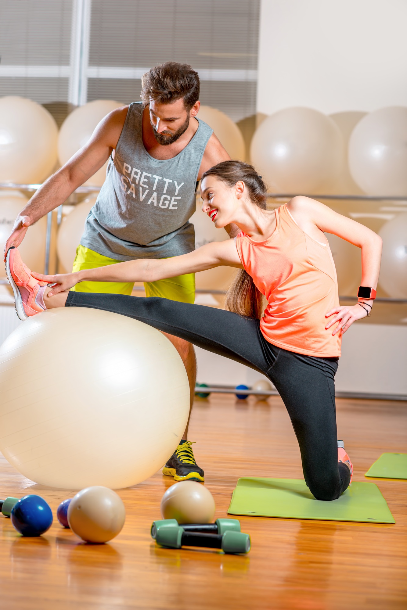 Dehntraining auf dem Medi Ball – gelenkschonende Beweglichkeit fördern Frau dehnt sich mit Trainer auf einem Gymnastikball in der Physiotherapiepraxis Paderborn